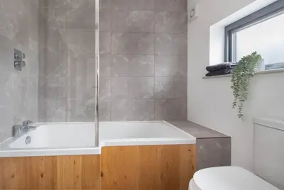 a bathroom with a white tub and a toilet at Zest Homes 87b Bridge Street in Leominster