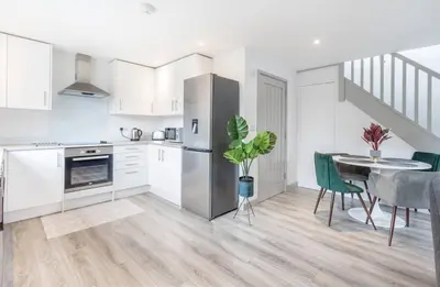 a kitchen and dining room with a table and a refrigerator at Zest Homes 87b Bridge Street in Leominster