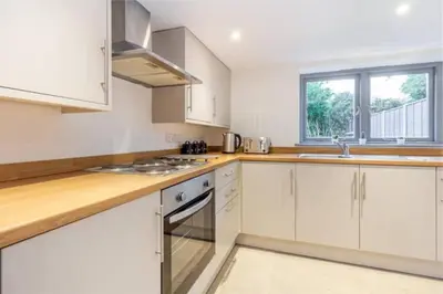 a white kitchen with white cabinets and a window at Zest Homes 87 Bridge Street in Leominster