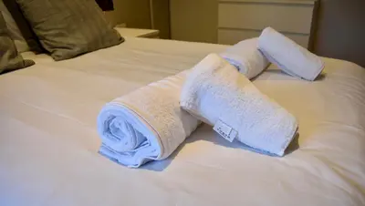 two rolled towels on top of a bed at Zest Homes 87a Bridge Street in Leominster