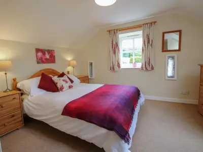 a bedroom with a large bed and a window at Little Barn in Oswestry