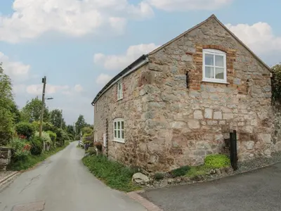 a stone building with a window on the side of a road at Little Barn in Oswestry