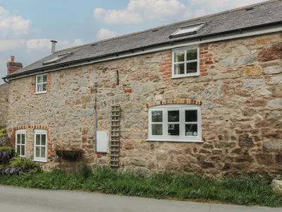 an old stone house with white windows on a street at Little Barn in Oswestry