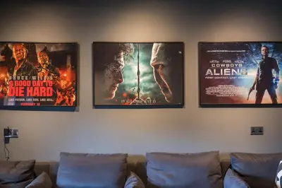 three movie posters on a wall above a couch at Ty Cefn by Birch Stays in Llangyniew