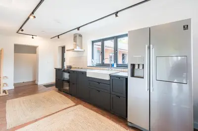 a kitchen with a stainless steel refrigerator and a sink at Ty Cefn by Birch Stays in Llangyniew