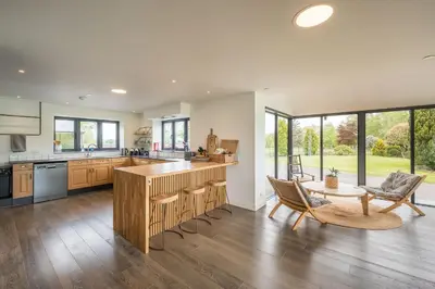 a kitchen with a counter and a table and chairs at Ty Cefn by Birch Stays in Llangyniew