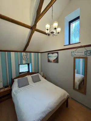 a bedroom with a white bed and a mirror at Nanternis Farm in New Quay