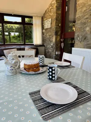 a table with a table cloth with a cake on it at Nanternis Farm in New Quay