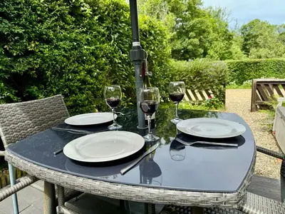 a table with plates and glasses of wine on it at Nanternis Farm in New Quay
