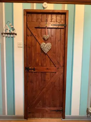 a wooden door with a heart hanging on it at Nanternis Farm in New Quay