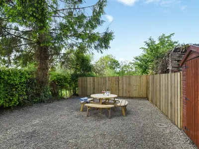 a patio with a table and a bench and a fence at Ford Farm in Ludlow