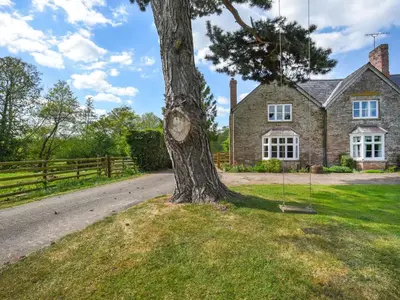 a tree in front of a house at Ford Farm in Ludlow