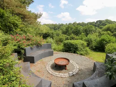 a circular garden with a bench and stairs at The Old Barn in Lampeter
