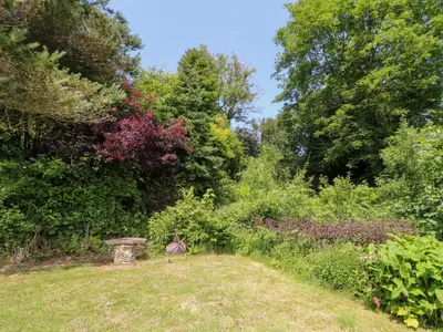 a garden with a birdbath in the middle of a field at The Old Barn in Lampeter