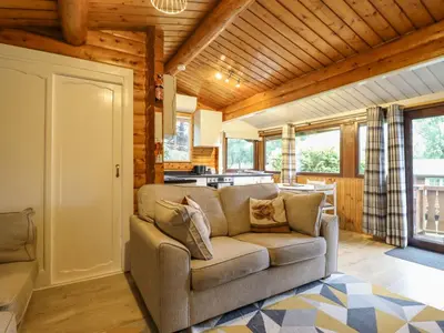 a living room with a couch and a kitchen at Swn Yr Afon - No 333 in Trawsfynydd