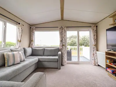 a living room with a couch and a tv at 8 Puffin Way in Llwyngwril