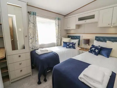a bedroom with two beds and a window at 34 The Beaumont in New Quay