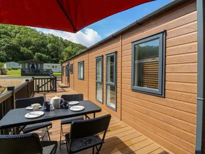 a deck with tables and chairs on a tiny house at 34 The Beaumont in New Quay