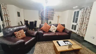 a living room with two leather couches and a coffee table at One-Bedroom Cottage in Snowdonia National Park in Dolgellau