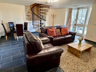 a living room with a leather couch and a coffee table at One-Bedroom Cottage in Snowdonia National Park in Dolgellau
