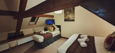 a attic bedroom with two beds and a tv at One-Bedroom Cottage in Snowdonia National Park in Dolgellau