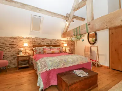 a bedroom with a bed and a stone wall at The Art House in Leominster