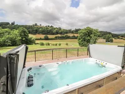 a jacuzzi tub on a balcony with a view at Stud Farm House in Knighton