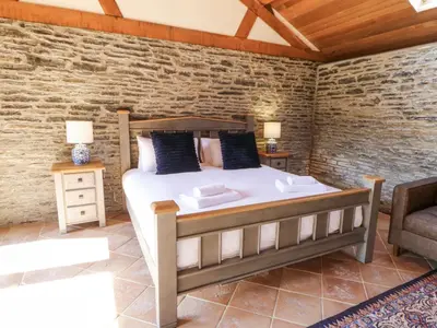 a bedroom with a bed and a couch and a chair at Stud Farm House in Knighton