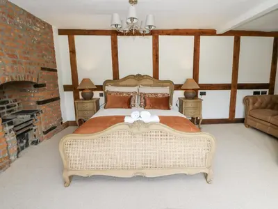 a bedroom with a large bed and a fireplace at Stud Farm House in Knighton