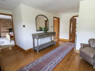 a living room with a table and a mirror at Stud Farm House in Knighton
