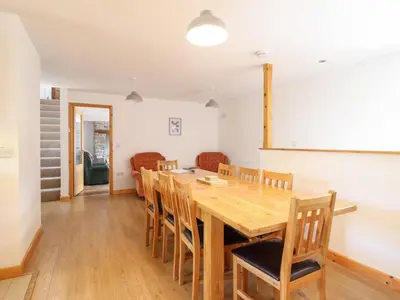 a dining room with a wooden table and chairs at Gwernffridd in Llanbrynmair
