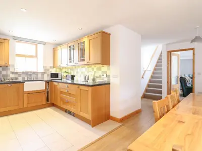 a large kitchen with wooden cabinets and a table at Gwernffridd in Llanbrynmair