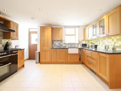 a large kitchen with wooden cabinets and black counter tops at Gwernffridd in Llanbrynmair