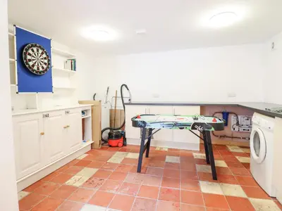 a kitchen with a table and a dartboard on the wall at Gwernffridd in Llanbrynmair