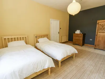a bedroom with two beds and a dresser in it at The Retreat at Glanrannell Park House in Llanwrda