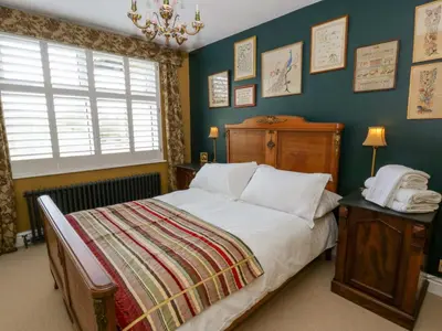a bedroom with a large bed and a window at The Retreat at Glanrannell Park House in Llanwrda