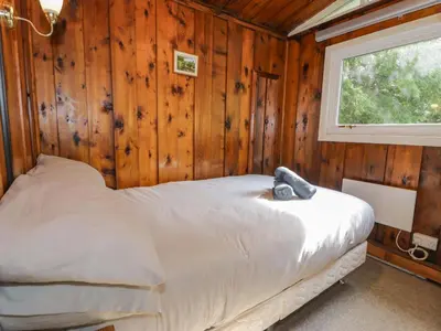 a bedroom with a bed in a wooden wall at Ty Bedwen in Machynlleth