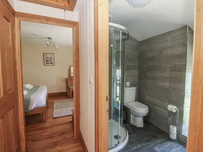 a bathroom with a toilet and a glass shower at Felin Gogoyan in Tregaron
