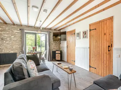 a living room with a couch and a table at The Old Cowsheds 2 - Shippon - Uk49787 in Cribyn