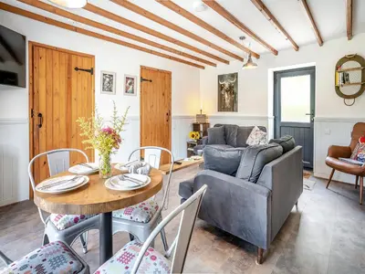 a living room with a table and a couch at The Old Cowsheds 2 - Shippon - Uk49787 in Cribyn