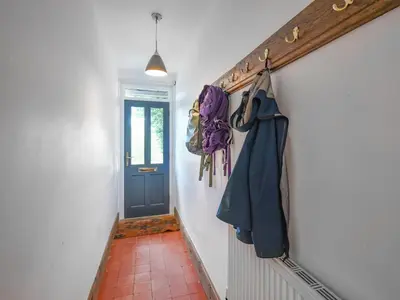 a hallway with a blue door and a hallwayngth at Clee View Cottage in Ludlow