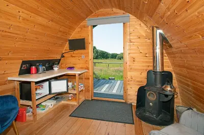 a room with a wood stove in a cabin at Scenic Pet Friendly Pod in Talybont Aberystwyth in Aberystwyth