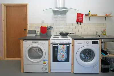 a kitchen with two washing machines and a stove at Scenic Pet Friendly Pod in Talybont Aberystwyth in Aberystwyth