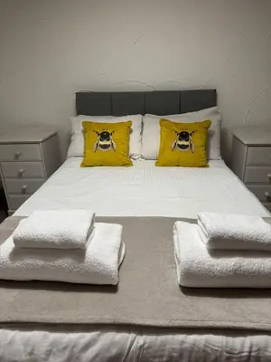 a bed with two yellow pillows with photographs on it at Vesna Affordable comfort in Newtown