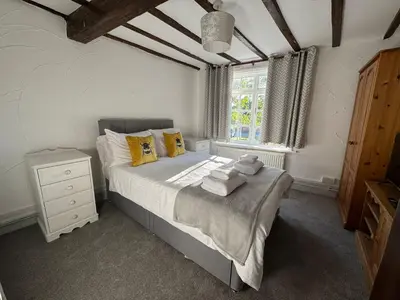 a bedroom with a bed with yellow pillows and a window at Vesna Affordable comfort in Newtown