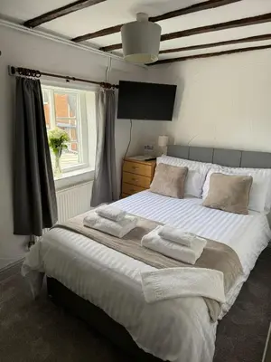 a bedroom with a large bed with towels on it at Vesna Affordable comfort in Newtown