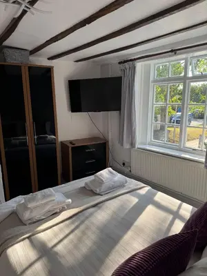 a bedroom with a bed and a large window at Vesna Affordable comfort in Newtown