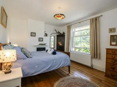 a bedroom with a blue bed and a window at 157 Watling Street South in Church Stretton