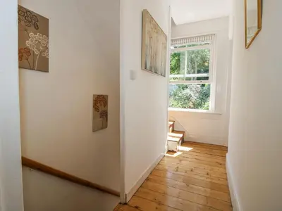 a room with a hallway with a window and wooden floors at 157 Watling Street South in Church Stretton