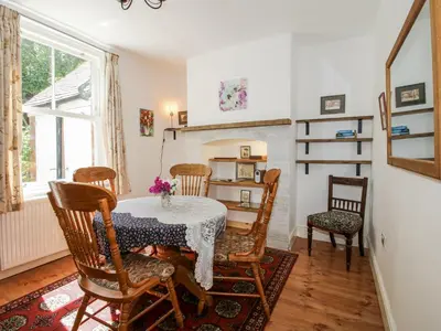 a dining room with a table and chairs and a fireplace at 157 Watling Street South in Church Stretton